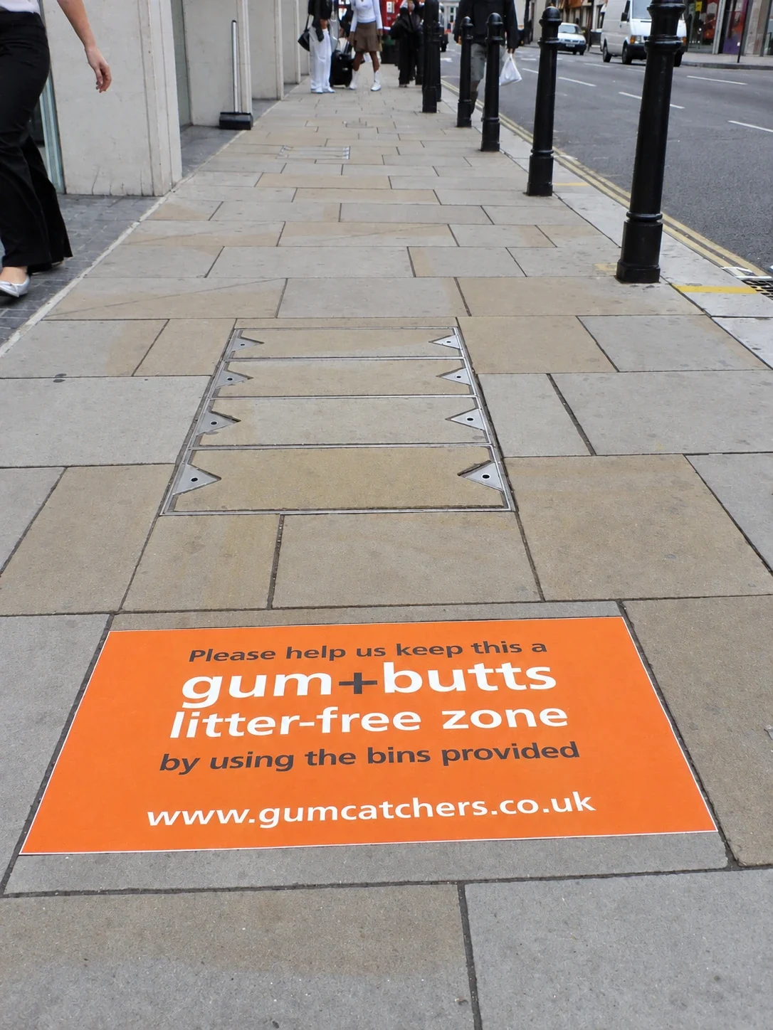 Orange Treadprint pavement graphic guiding pedestrians to keep the street free of gum and cigarette litter