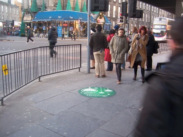 Green circular Treadprint on a busy shopping street